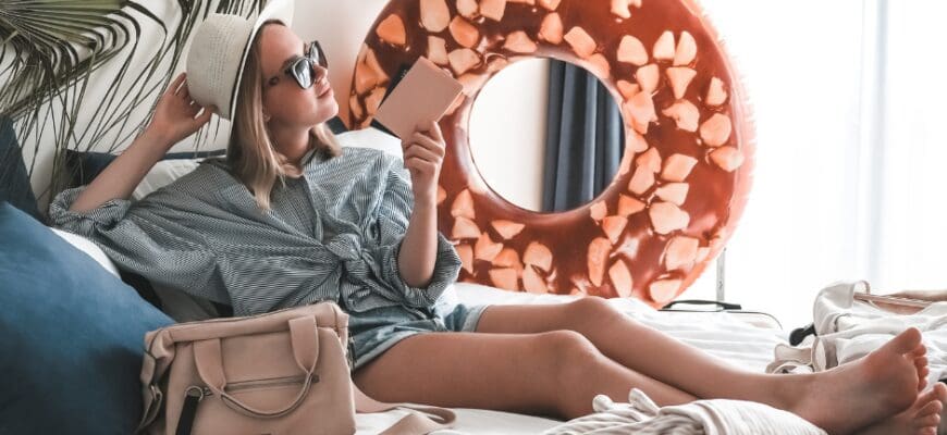 A woman lounging in a bright bedroom